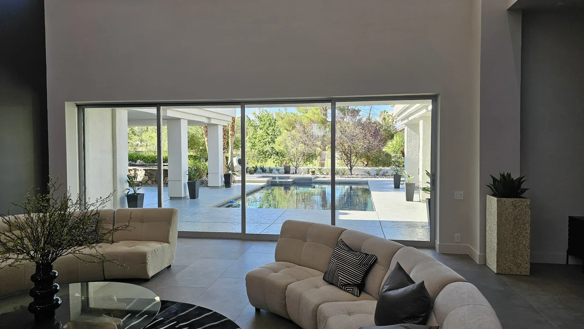 Multi-panel sliding glass doors opening from a living room toward a pool